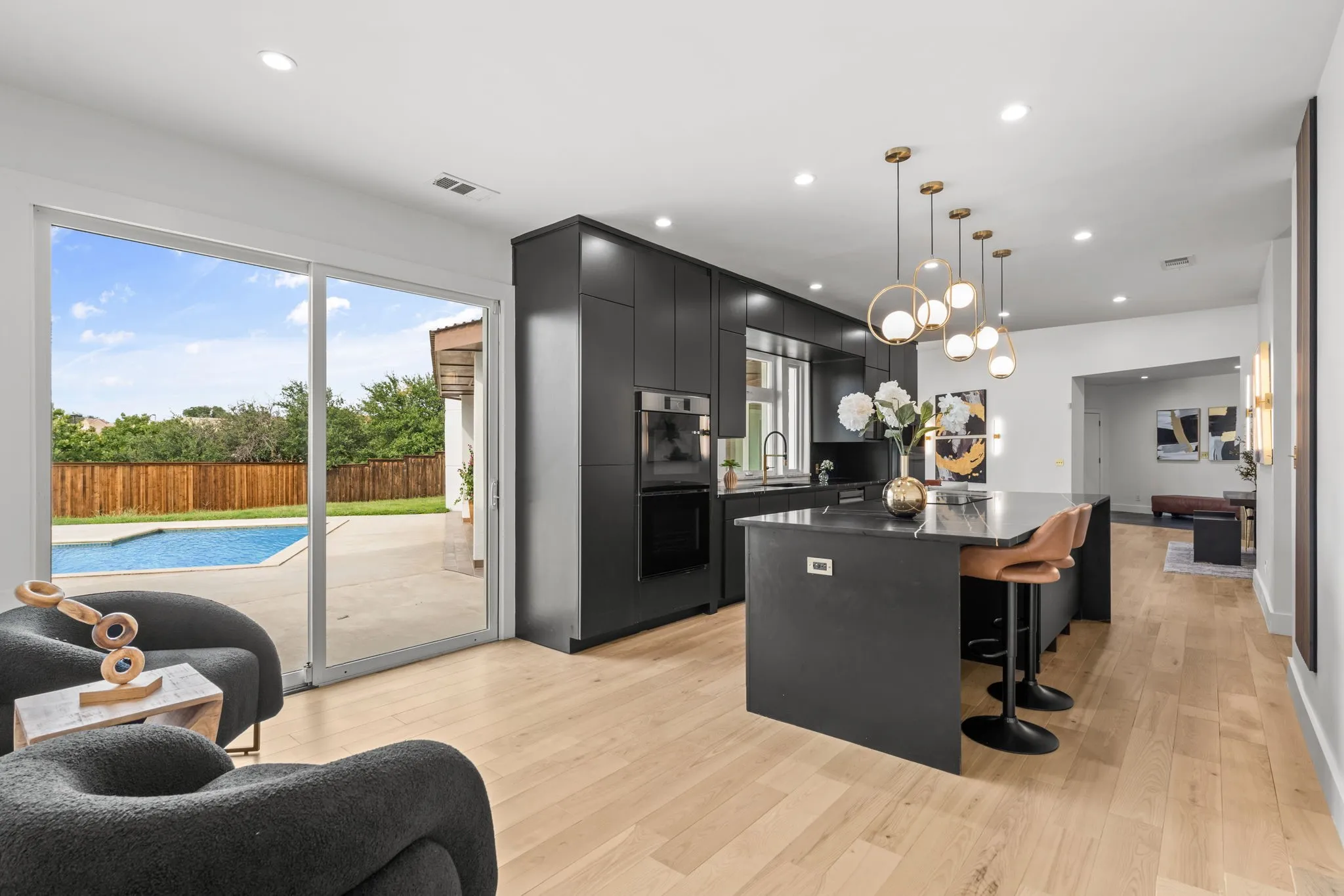 Modern kitchen featuring dark cabinetry, an integrated oven, and a large central island with seating