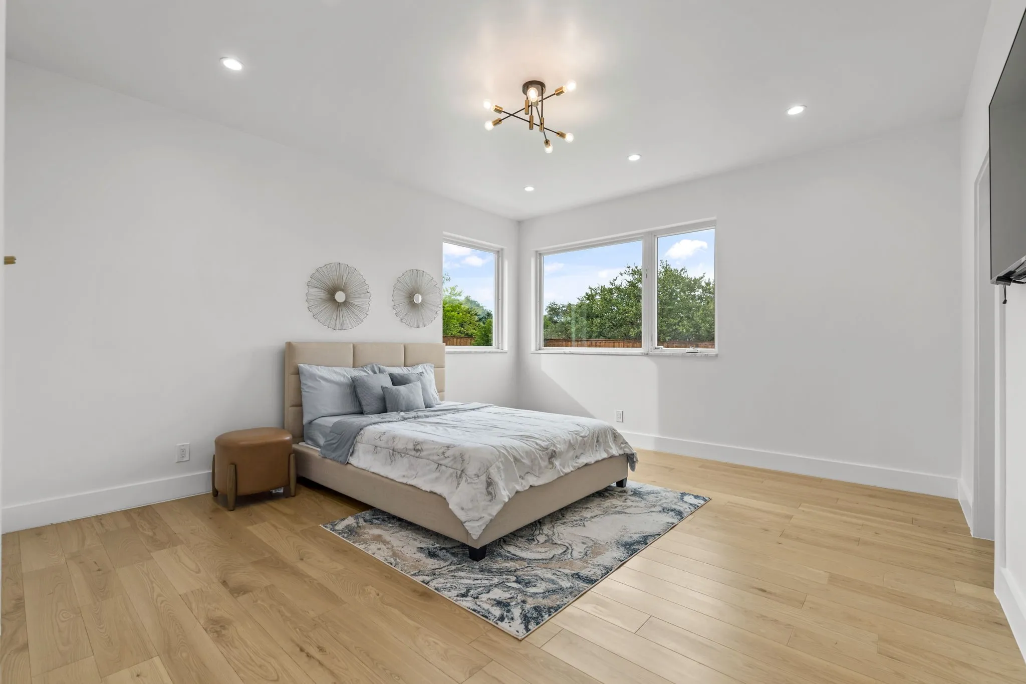 Bright room with light wood-finish flooring, white walls, and recessed lighting