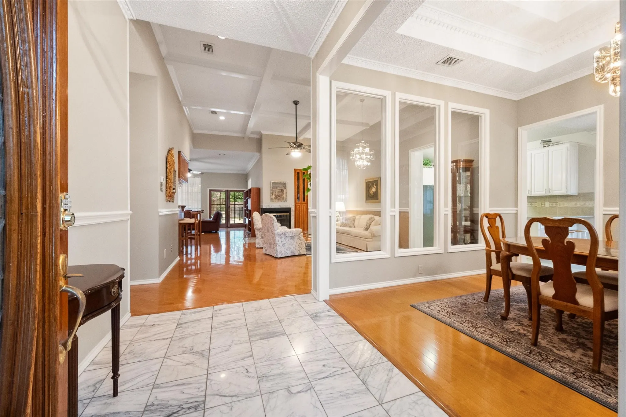 Entry foyer with marble tile flooring opening to a living area with wood flooring