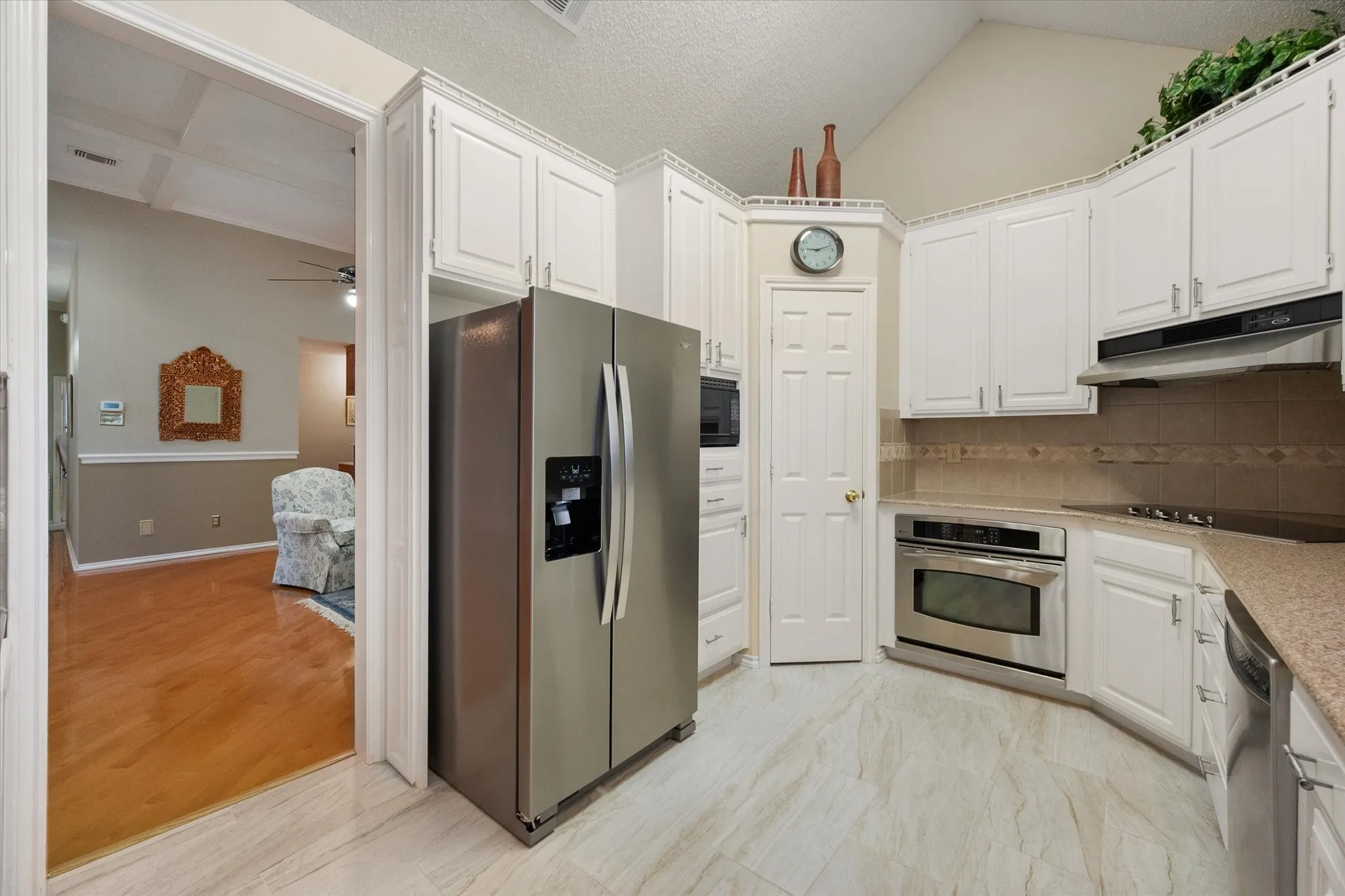 Kitchen featuring white cabinetry, stainless steel appliances, a built-in oven, and a tile backsplash
