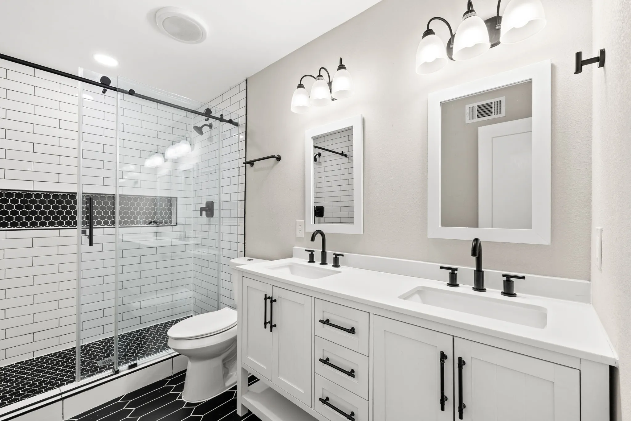 Double vanity with quartz countertop, undermount sinks, and matte black fixtures