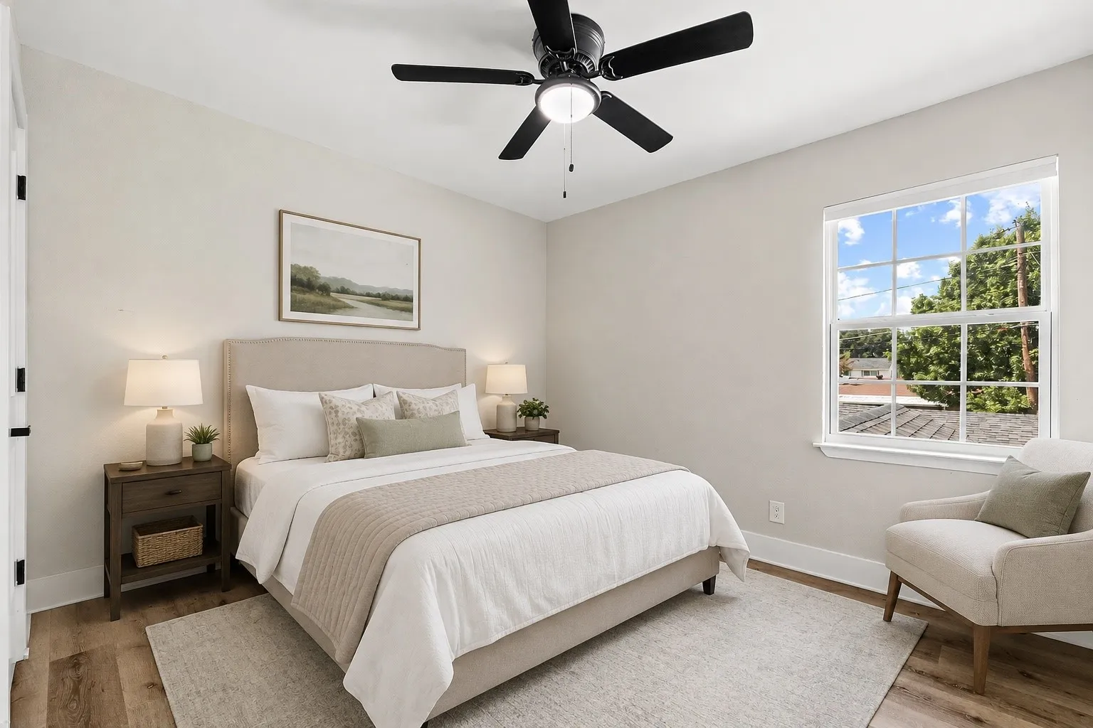 Light-filled room featuring wood-finish flooring, a ceiling fan with integrated lighting, and a large multi-pane window