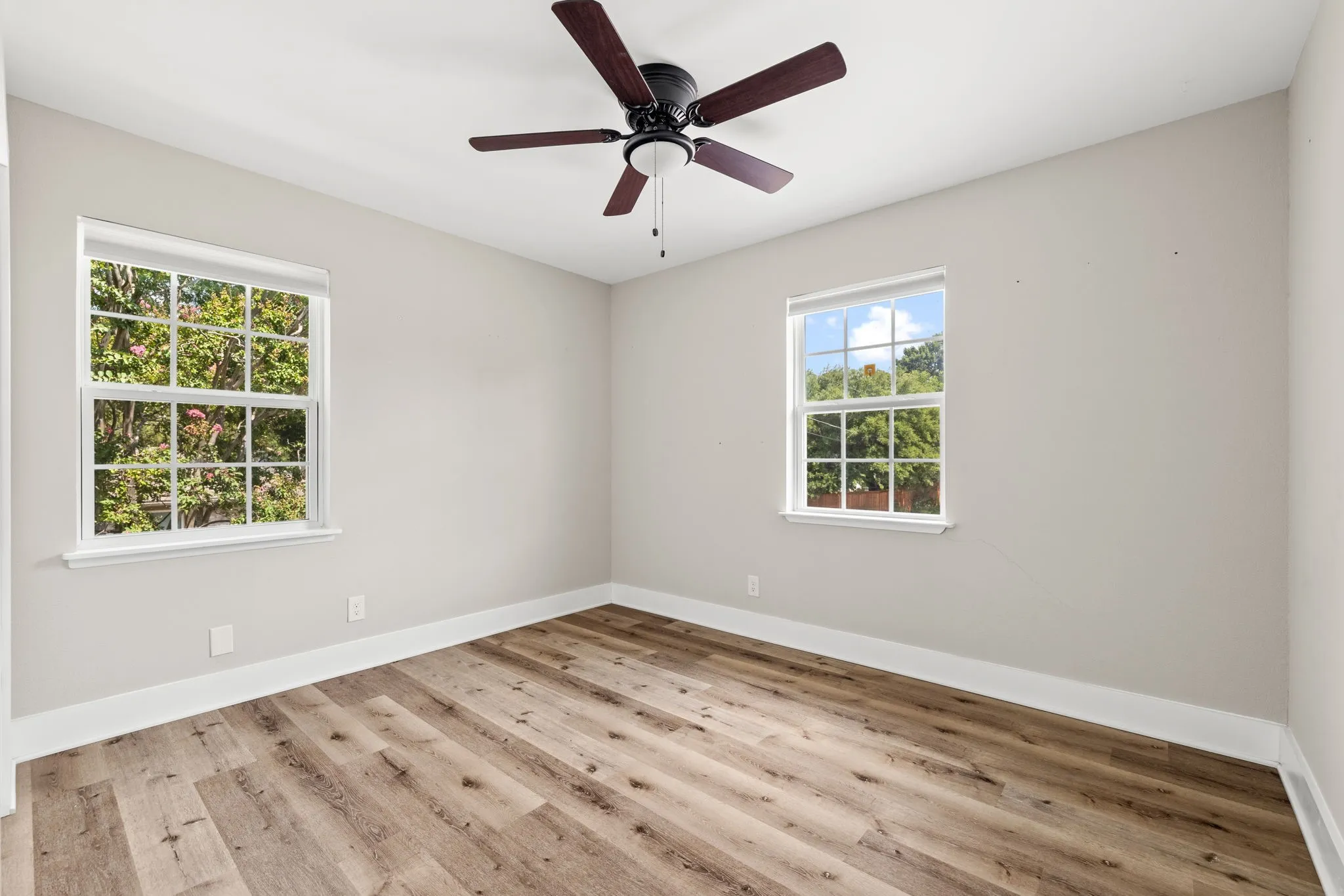 Bedroom featuring wood-finish flooring, light neutral wall tones, and white trim