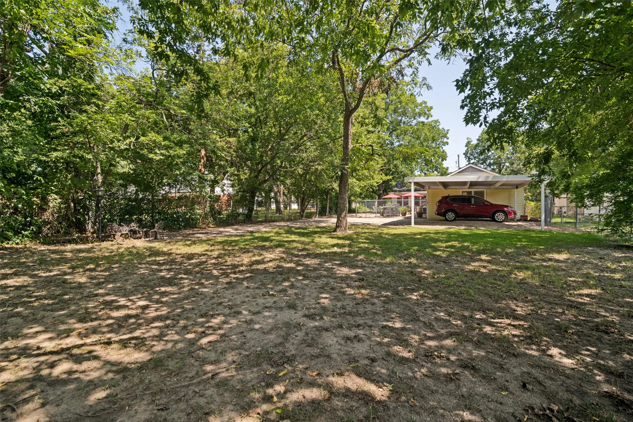 Large lot with attached garage, carport, and outdoor cooking area.