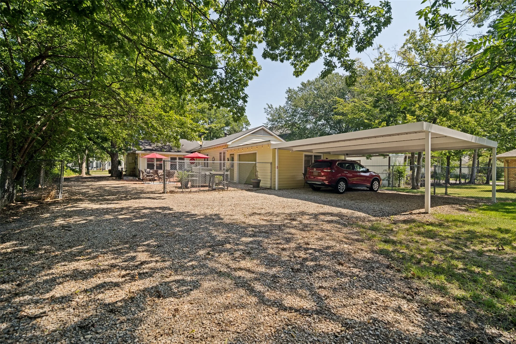 Large lot with attached garage, carport, and outdoor cooking area.