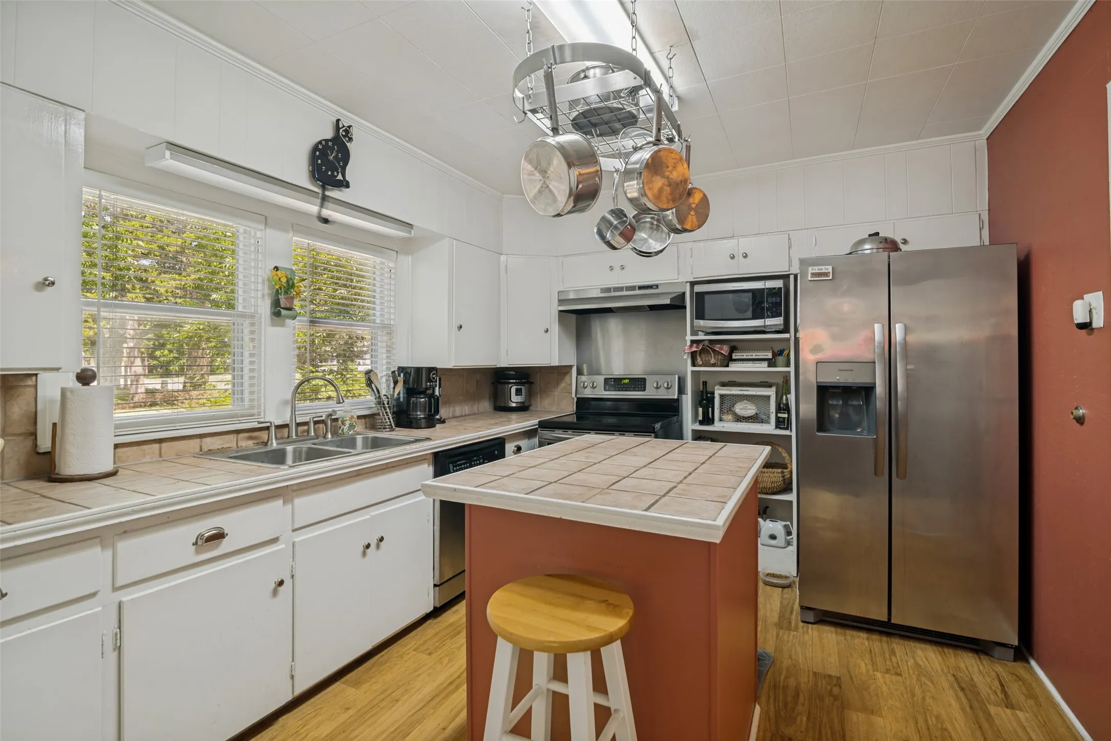 Kitchen with durable tile counters, am island, and ample cabinetry