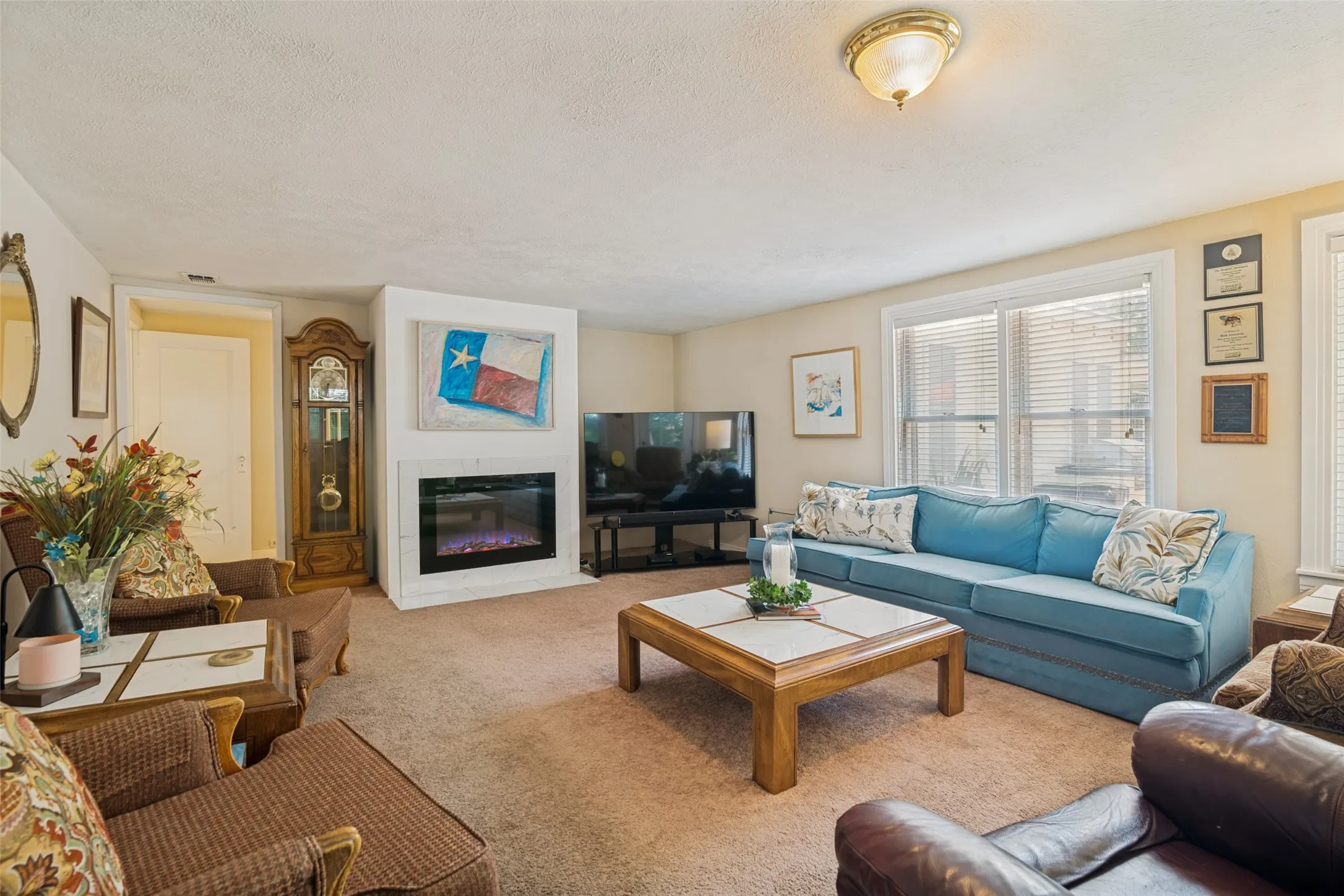 Family room off of kitchen with electruc fireplace and wood fireplace behind it