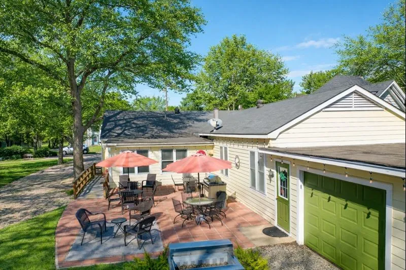 Large lot with attached garage, carport, and outdoor cooking area.