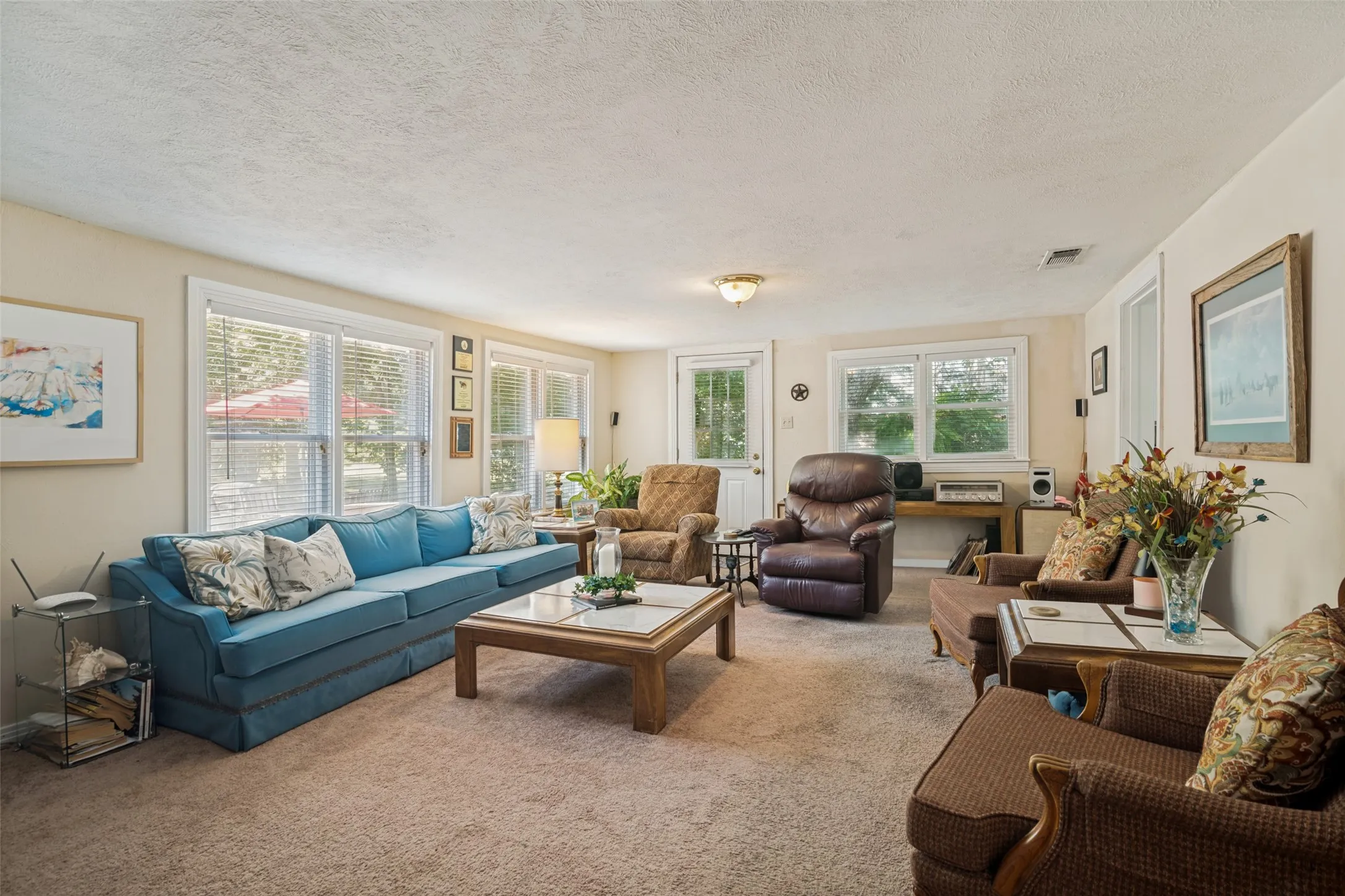 Family room off of kitchen with electric fireplace and wood fireplace behind it