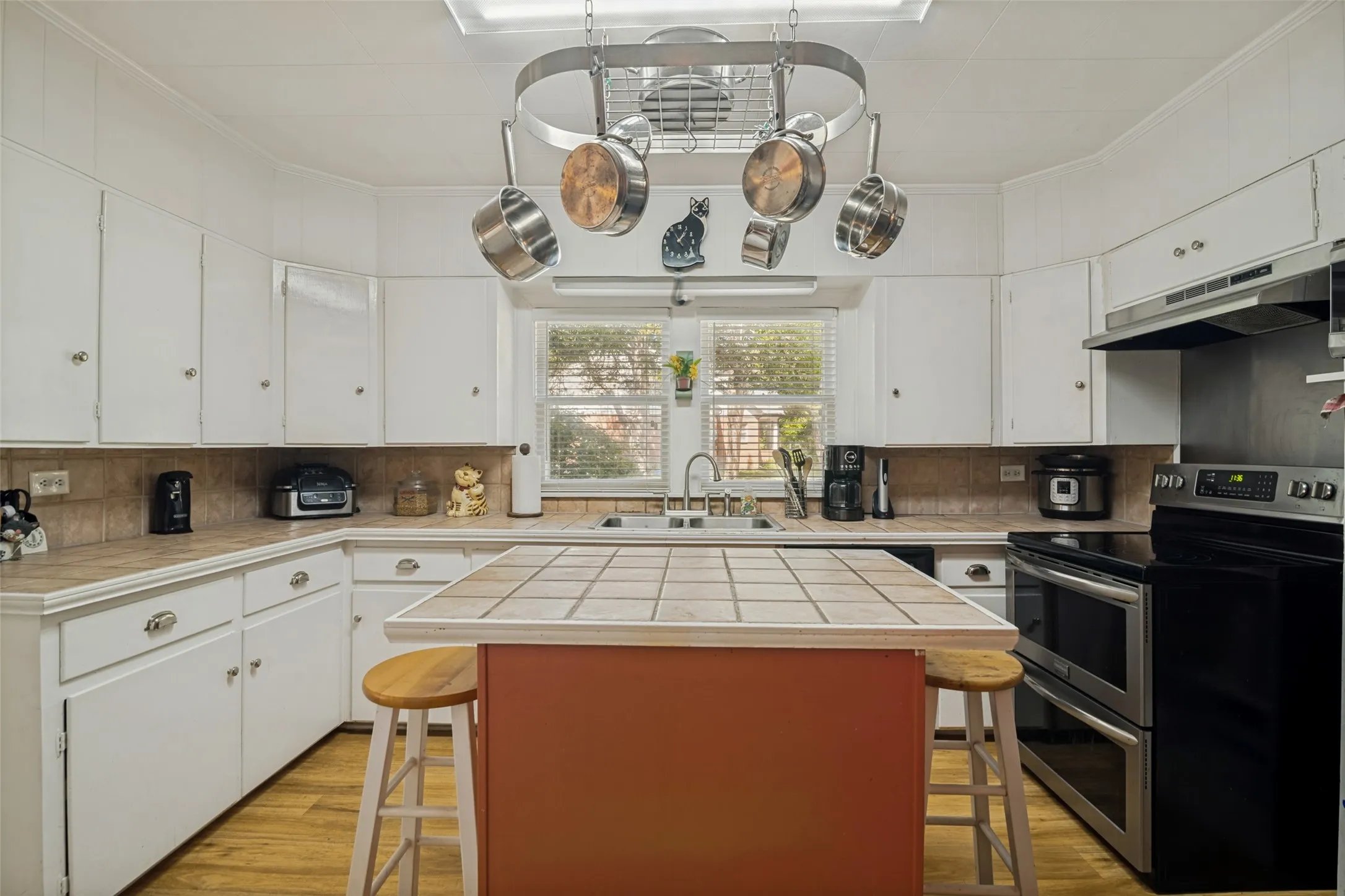 Kitchen with durable tile counters, am island, and ample cabinetry