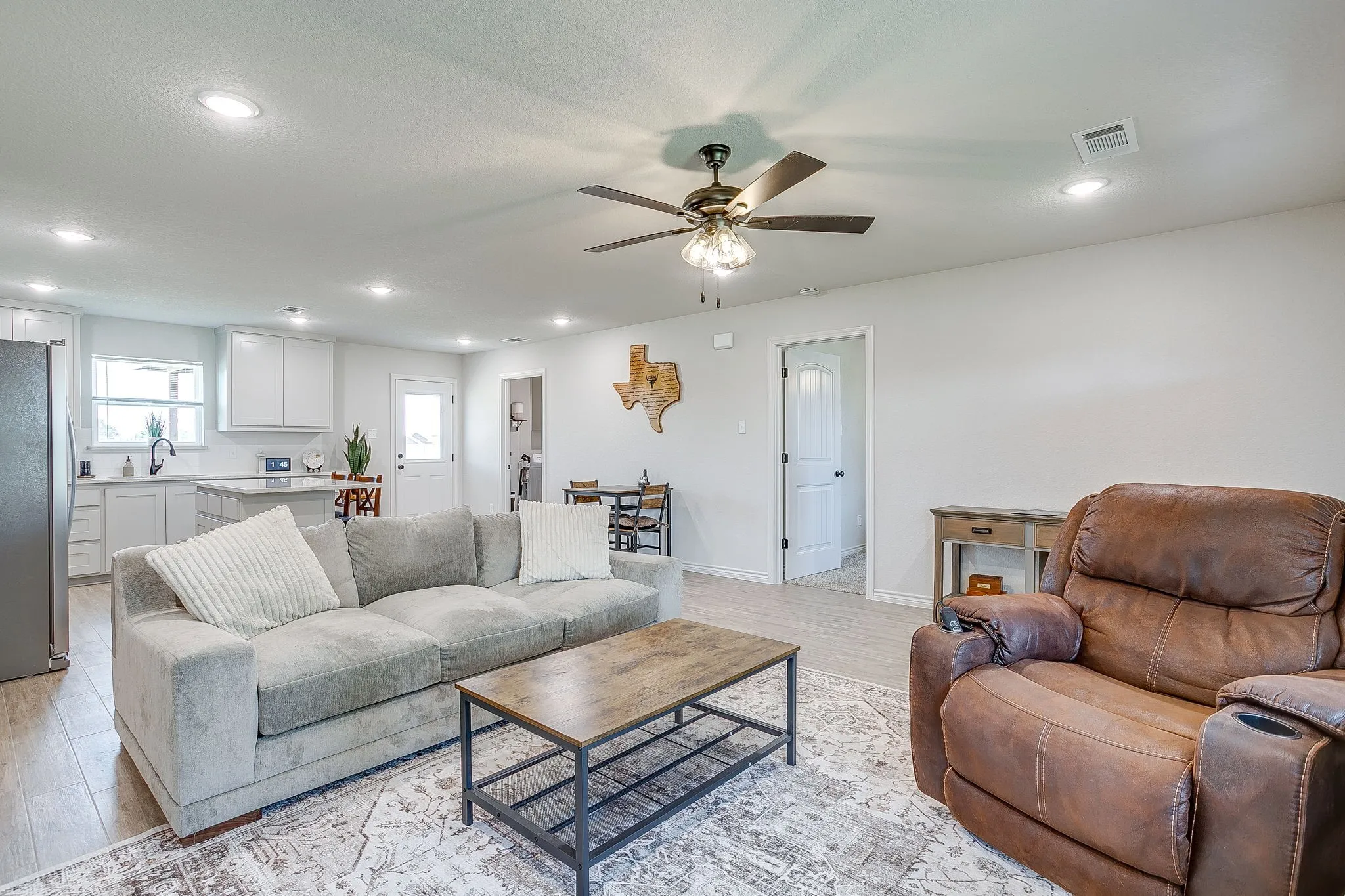 Open-concept living area featuring recessed lighting, a ceiling fan, and wood-finish flooring