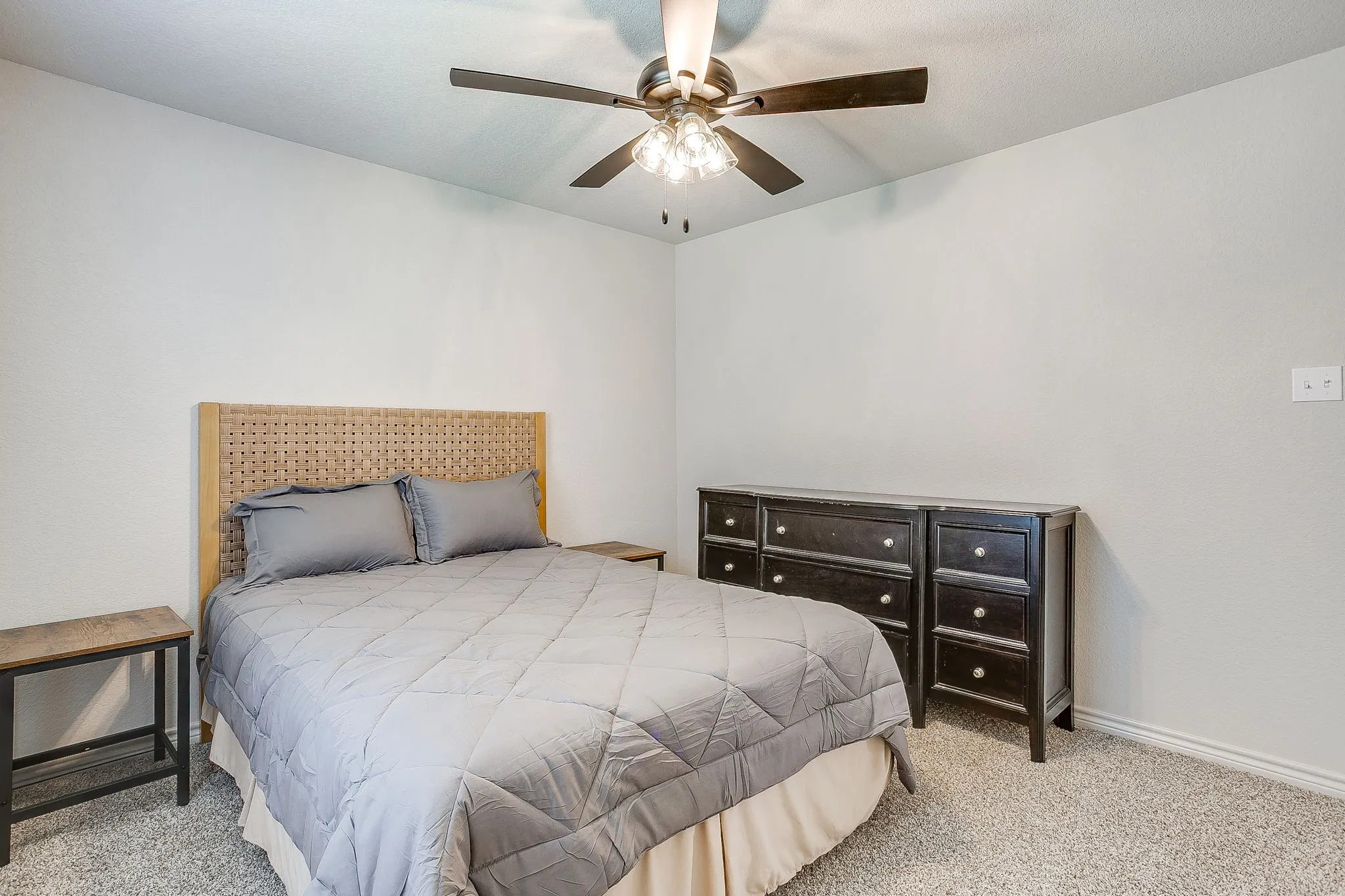 Wall-to-wall carpeting and a ceiling fan with integrated lighting