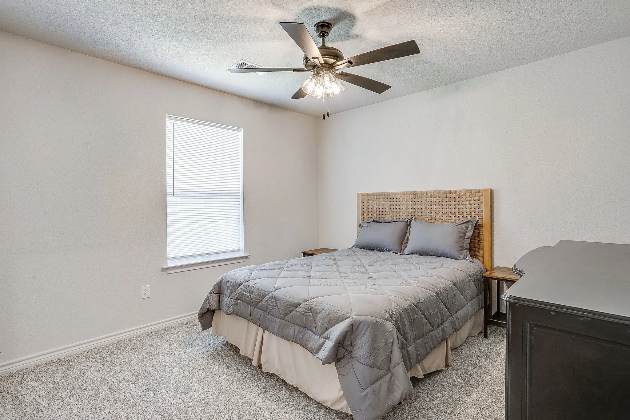 Wall-to-wall carpeting, window with roller shade, and ceiling fan with integrated lighting