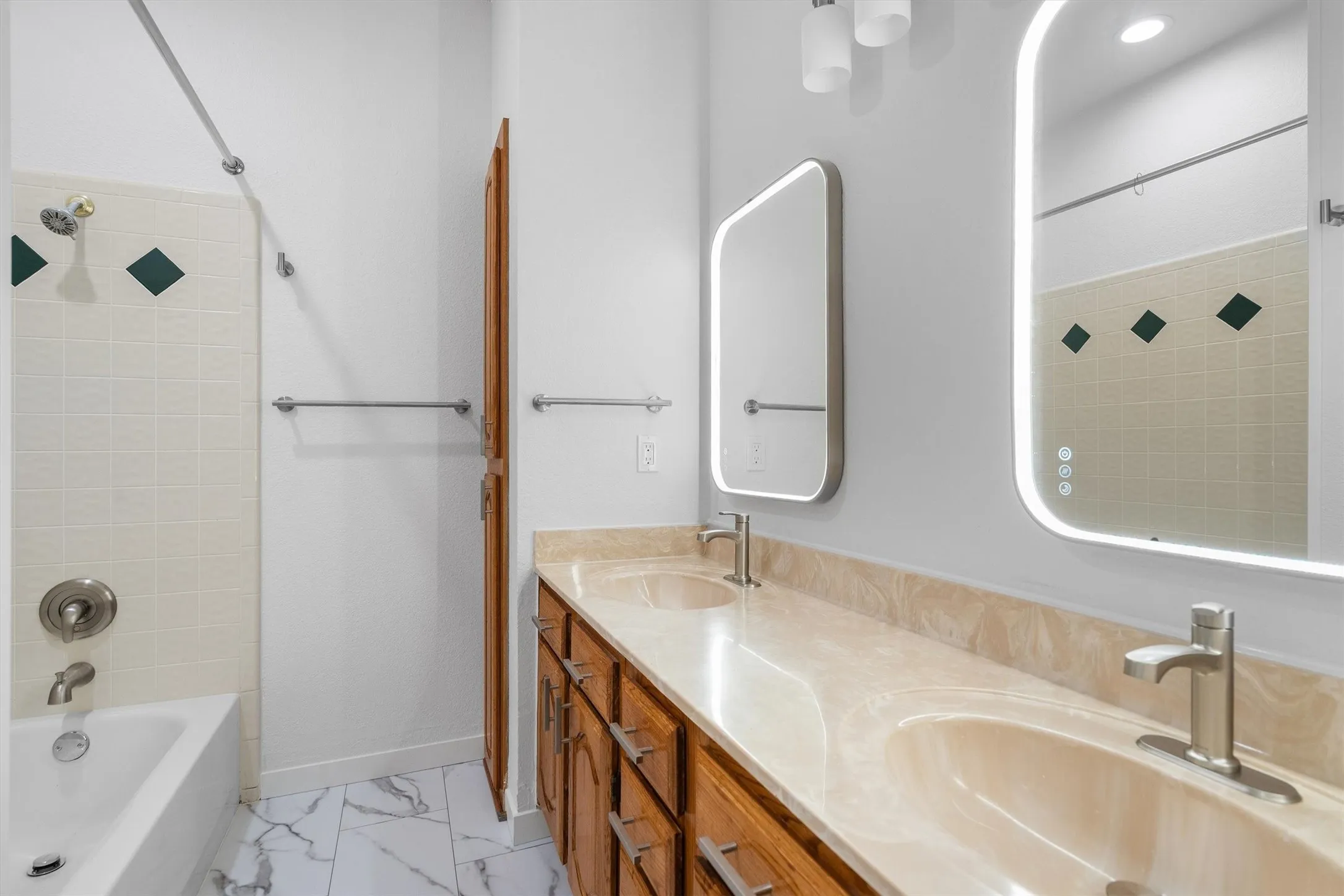 Bathroom featuring a dual vanity with integrated sinks, stone-finish countertop, and wood cabinetry