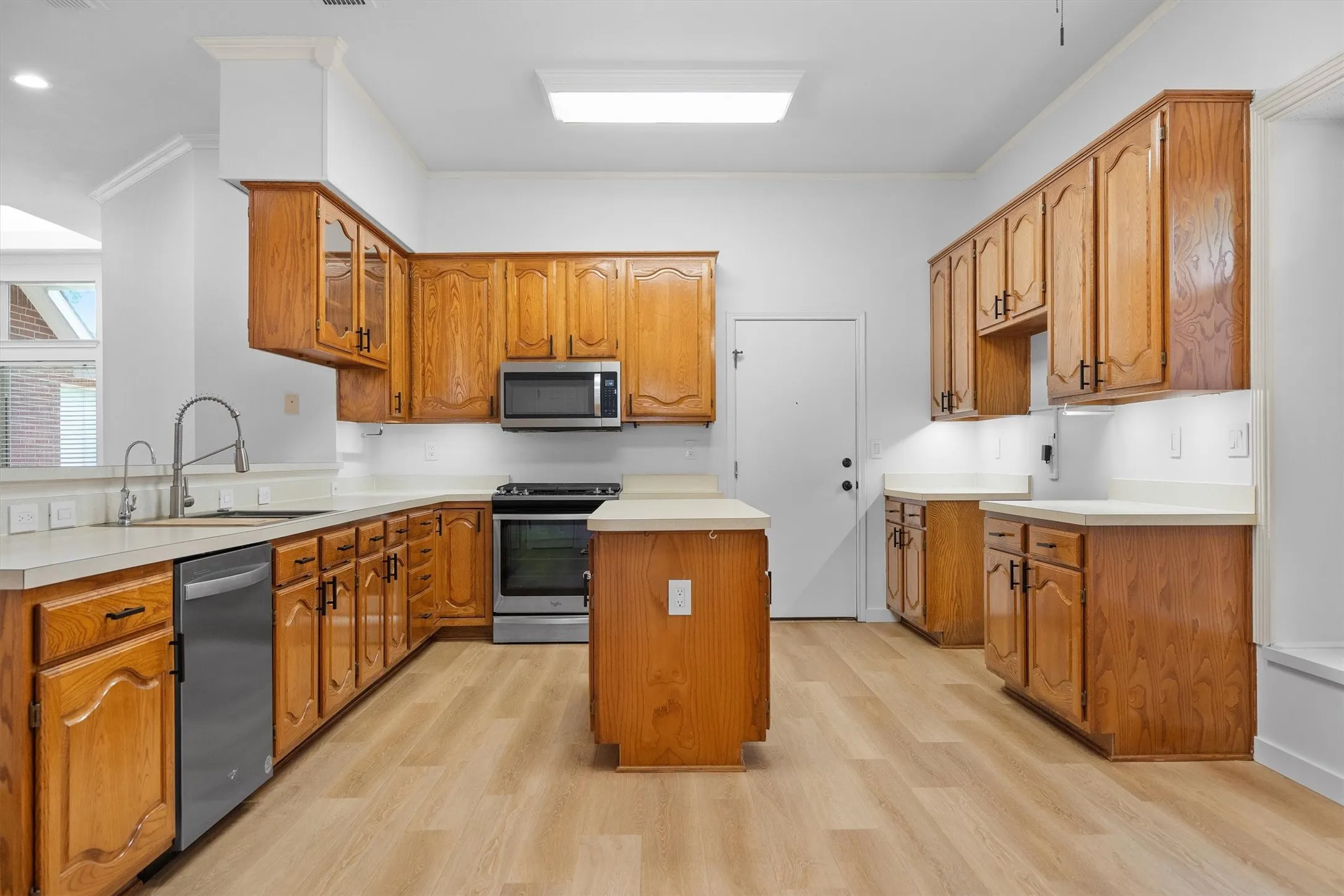 Kitchen featuring wood cabinetry, stainless steel appliances, and a central island