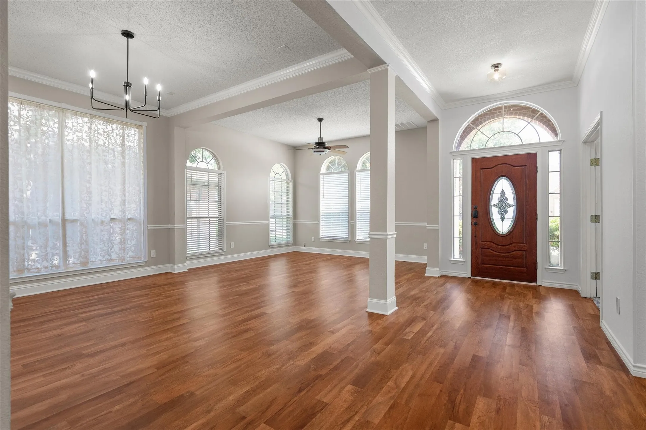 Inviting entry featuring a rich wood-finish door with decorative glass, flanked by sidelight windows and topped with an arched transom