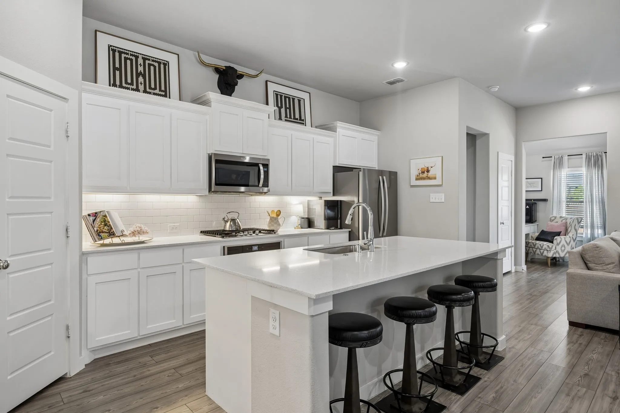 A kitchen that truly steals the show! With a spacious breakfast island, sleek under-cabinet lighting, a chef worthy gas range and plenty of cabinet and counter space, this kitchen is as functional as it is stylish. The crisp white subway tile backsplash adds a touch of modern charm, while the open layout flowing into the living and dining areas makes it perfect for hosting unforgettable gatherings.