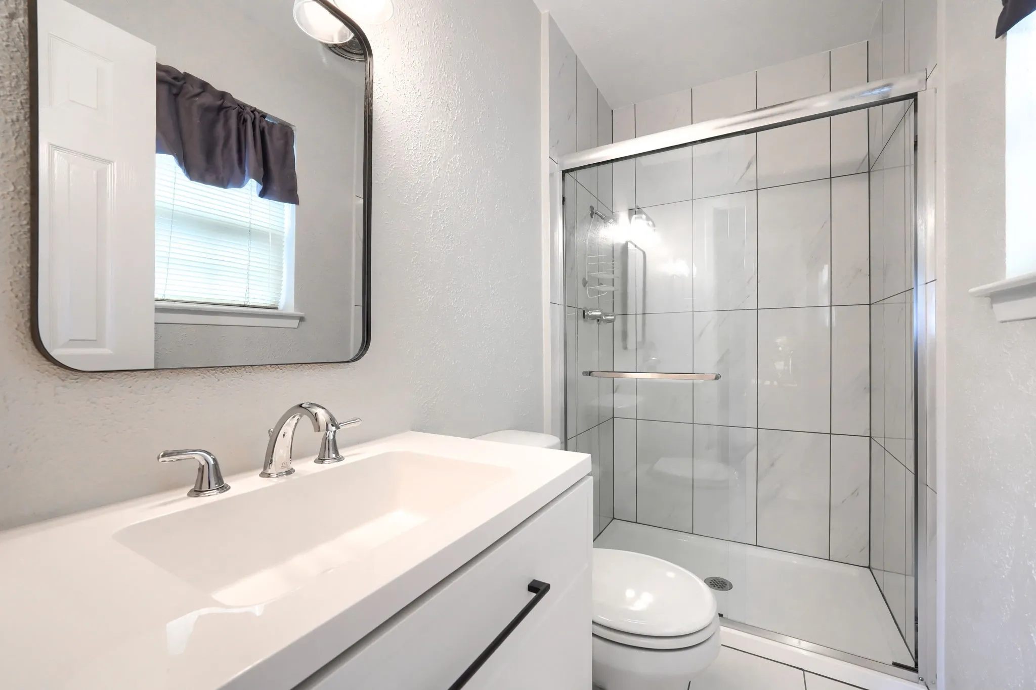 Modern bathroom featuring a single vanity with an integrated sink and chrome fixtures