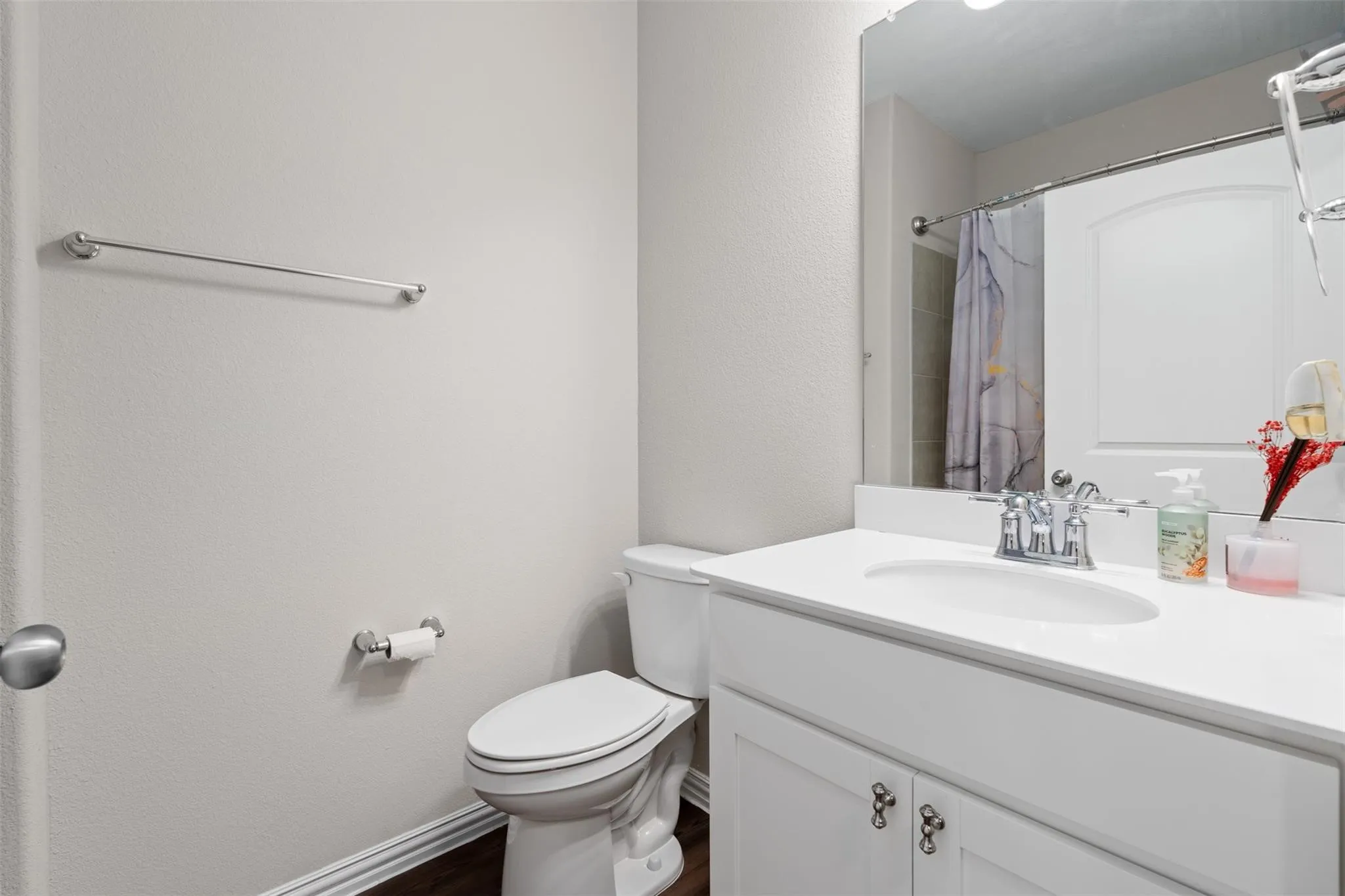 Bathroom featuring a white vanity with an integrated sink, chrome hardware, and a framed mirror