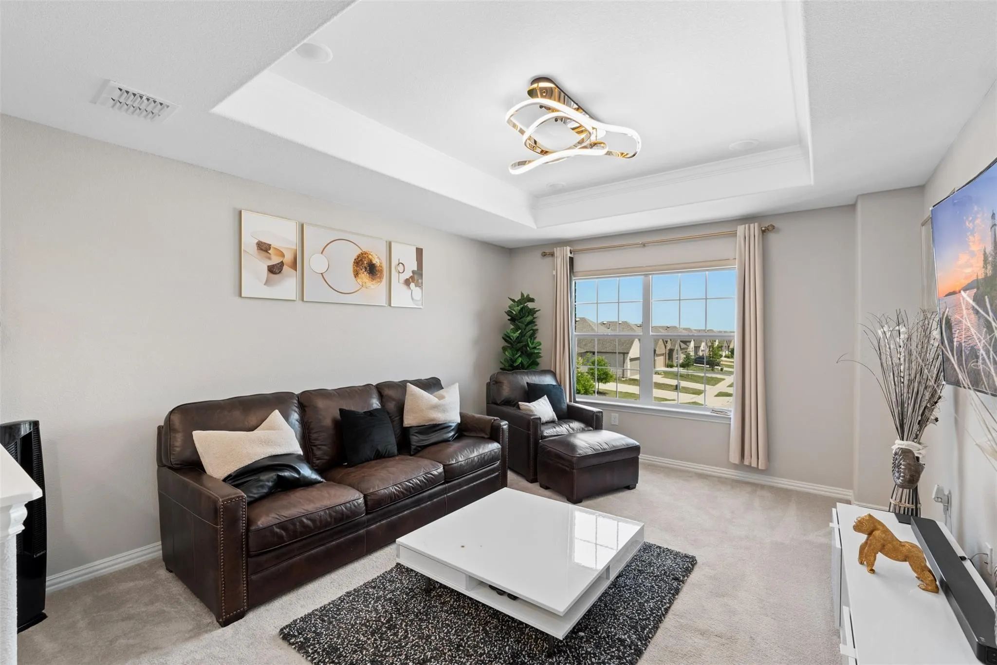 Tray ceiling with crown molding and a contemporary light fixture