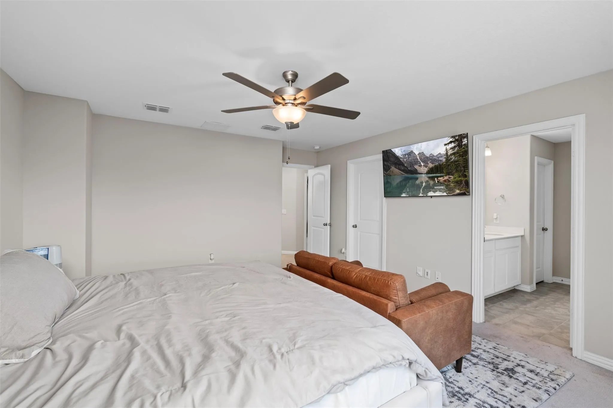 Spacious room featuring a ceiling fan with integrated lighting, neutral wall tones, and carpet flooring