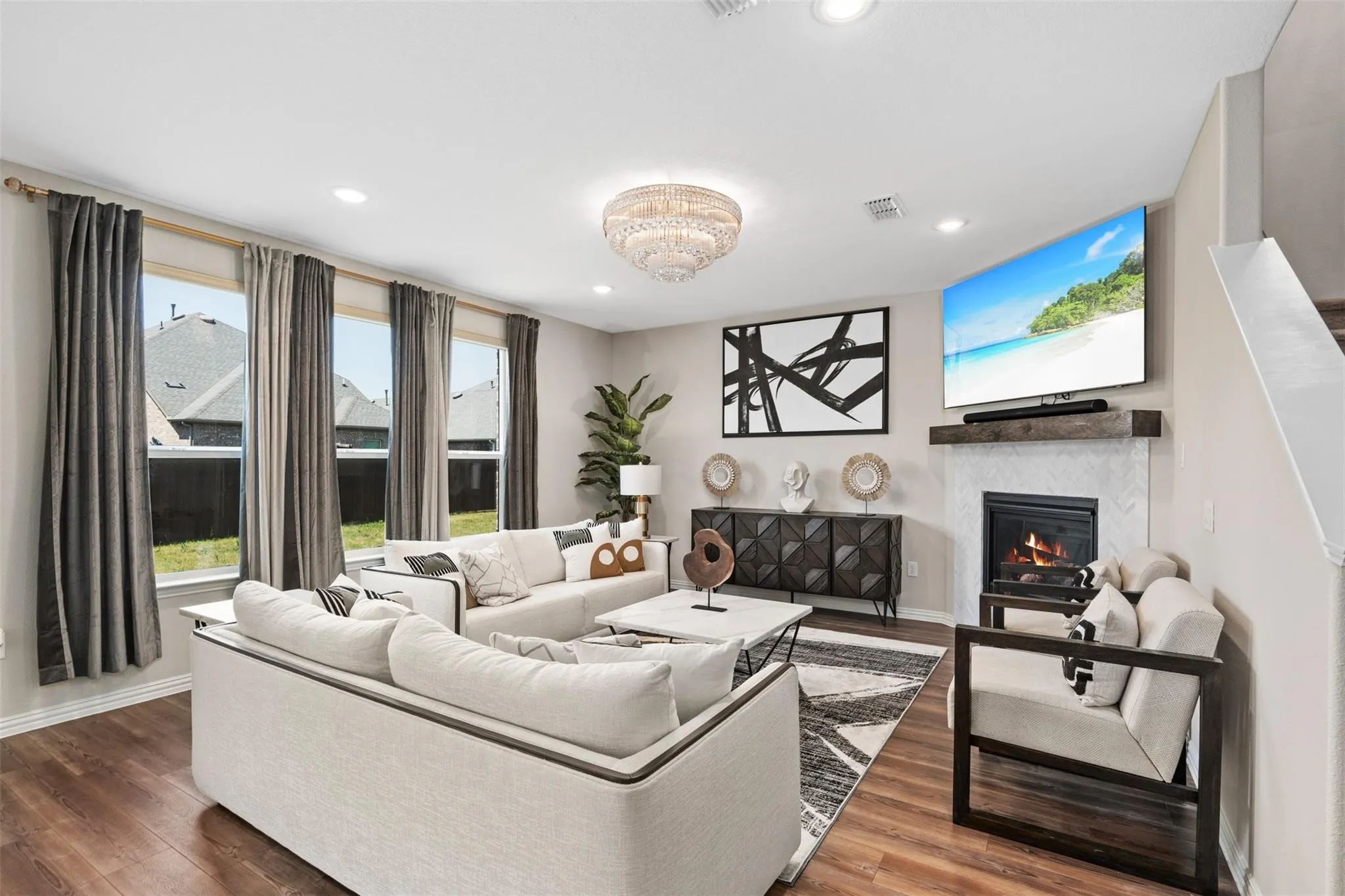 Spacious living area featuring wood-finish flooring, recessed lighting, and a decorative chandelier