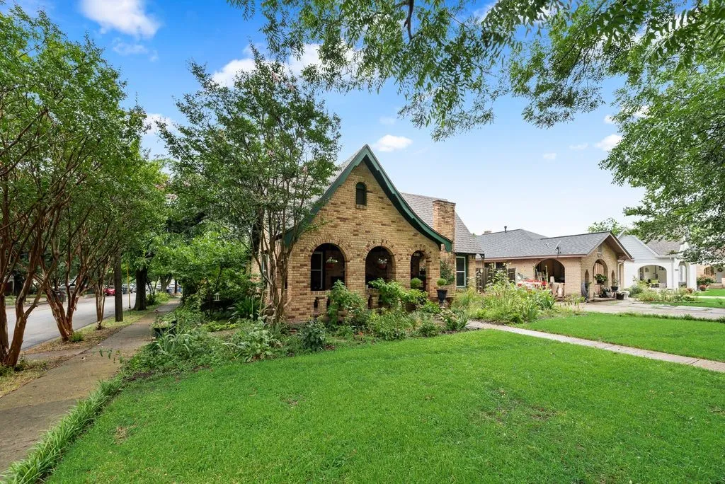 Brick exterior with arch details, gabled roofline, and established landscaping