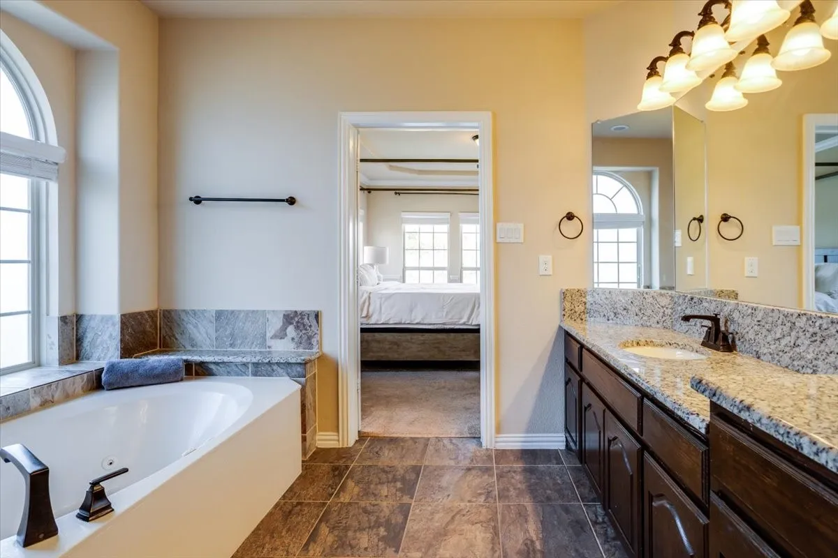 Ensuite bathroom with vanity and a tub with jets