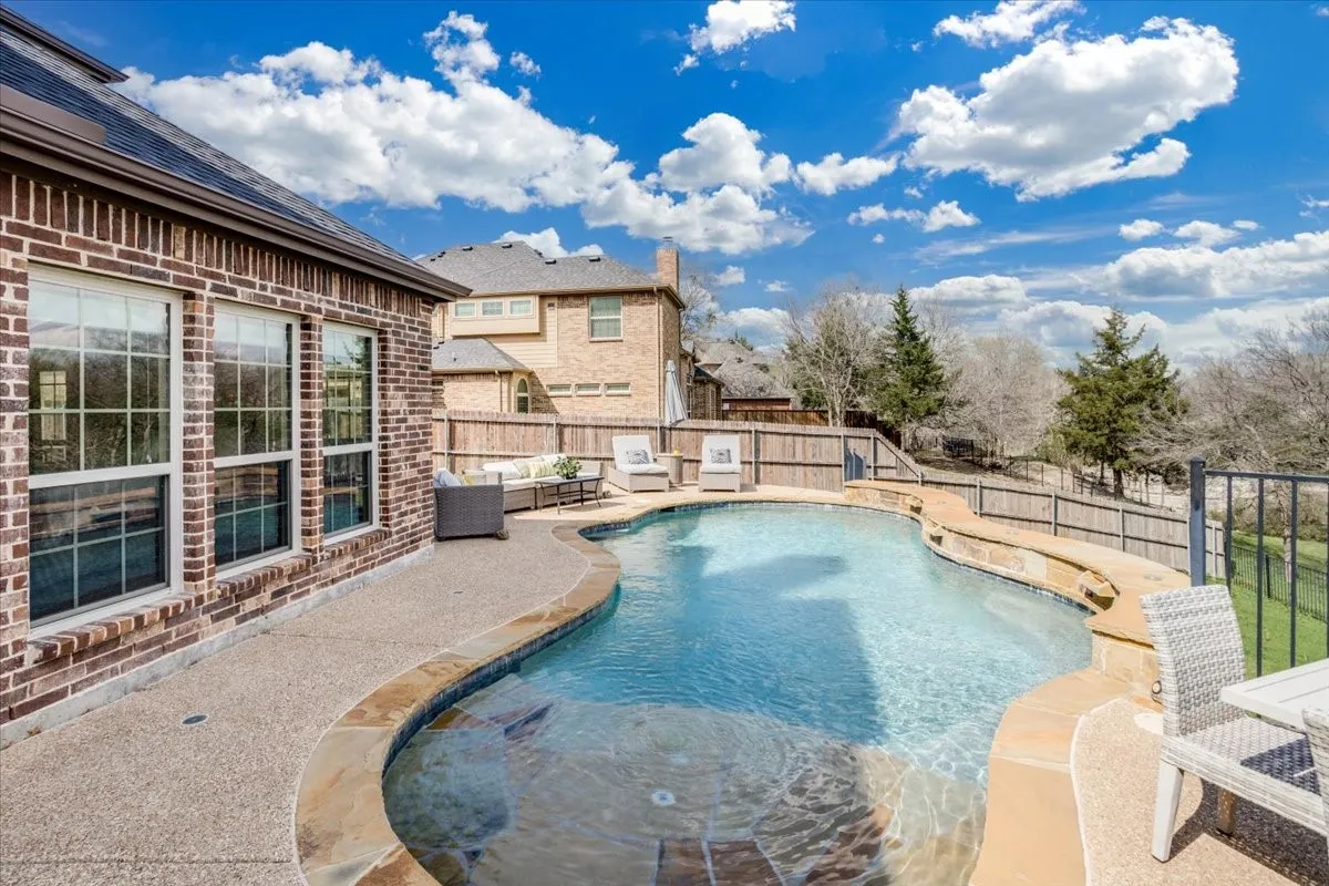 View of swimming pool featuring patio surround, a fenced backyard, and outdoor lounge area