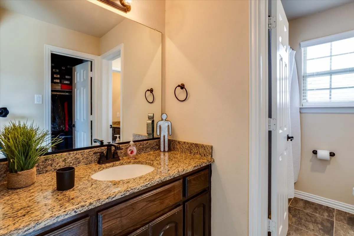 Full bath with vanity, a spacious closet, and a shower with curtain