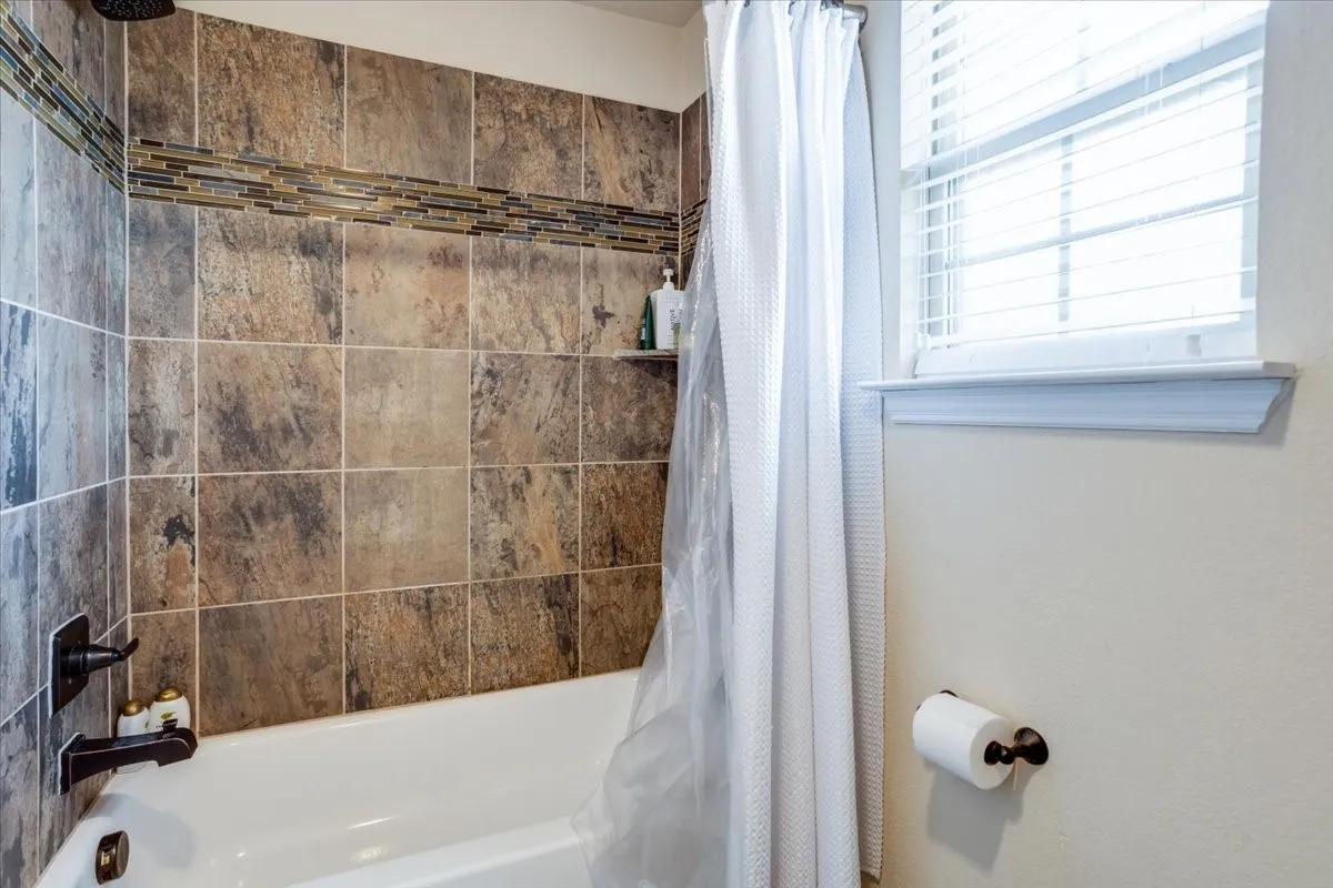Bathroom featuring shower / bath combination with curtain