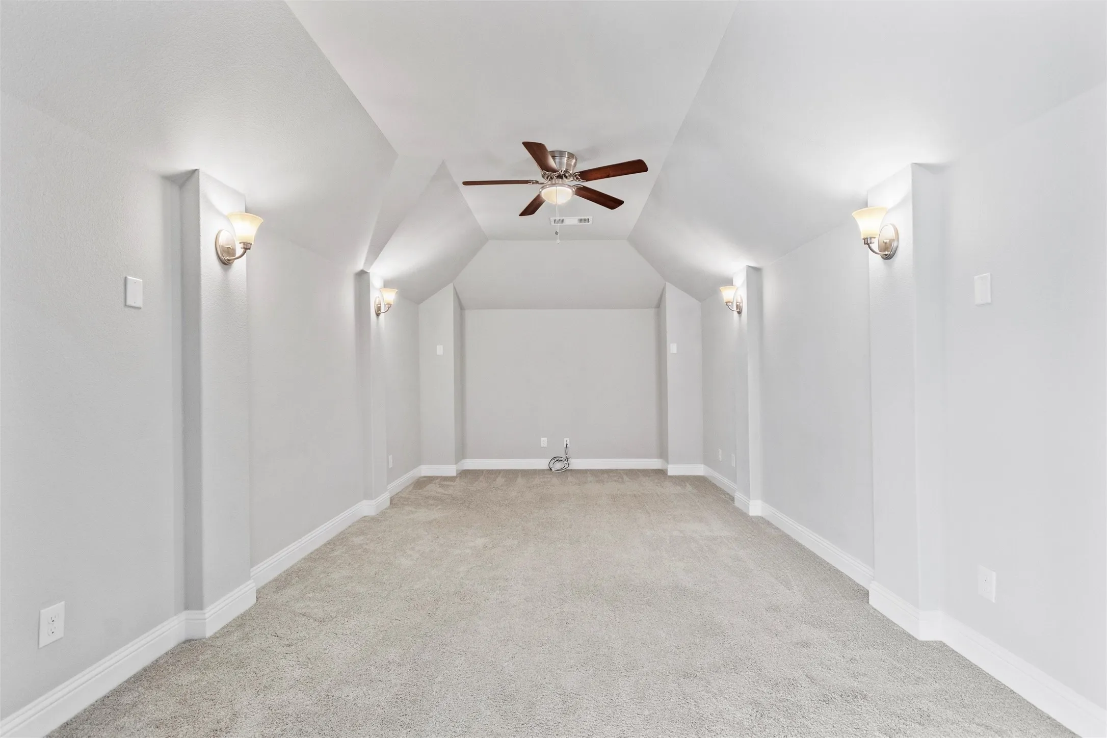 Additional living space featuring light carpet, ceiling fan, and lofted ceiling