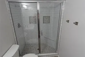 Shower enclosure with clear glass doors and a chrome frame