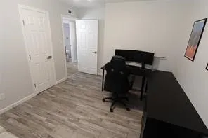 Room featuring wood-finish flooring, light gray wall paint, and white trim