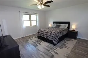 Bedroom with dark hardwood / wood-style flooring and ceiling fan