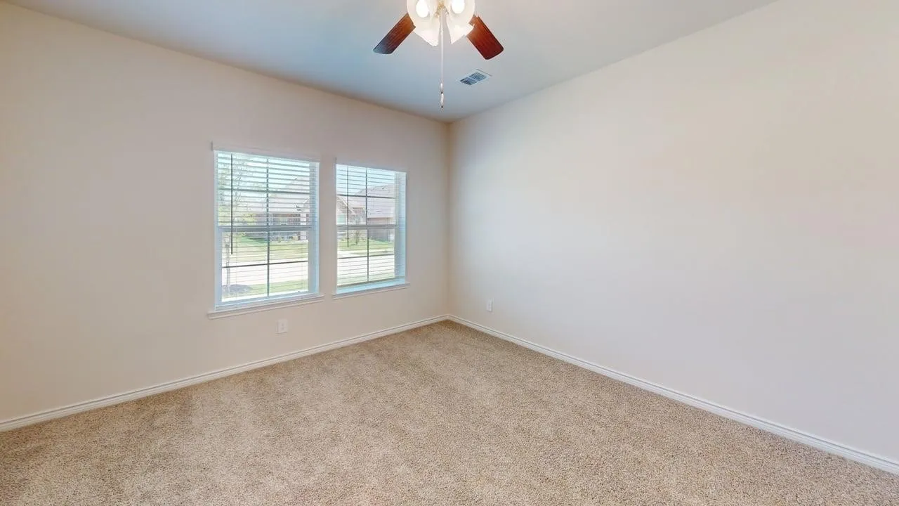 Carpeted room with neutral wall tones and white baseboards