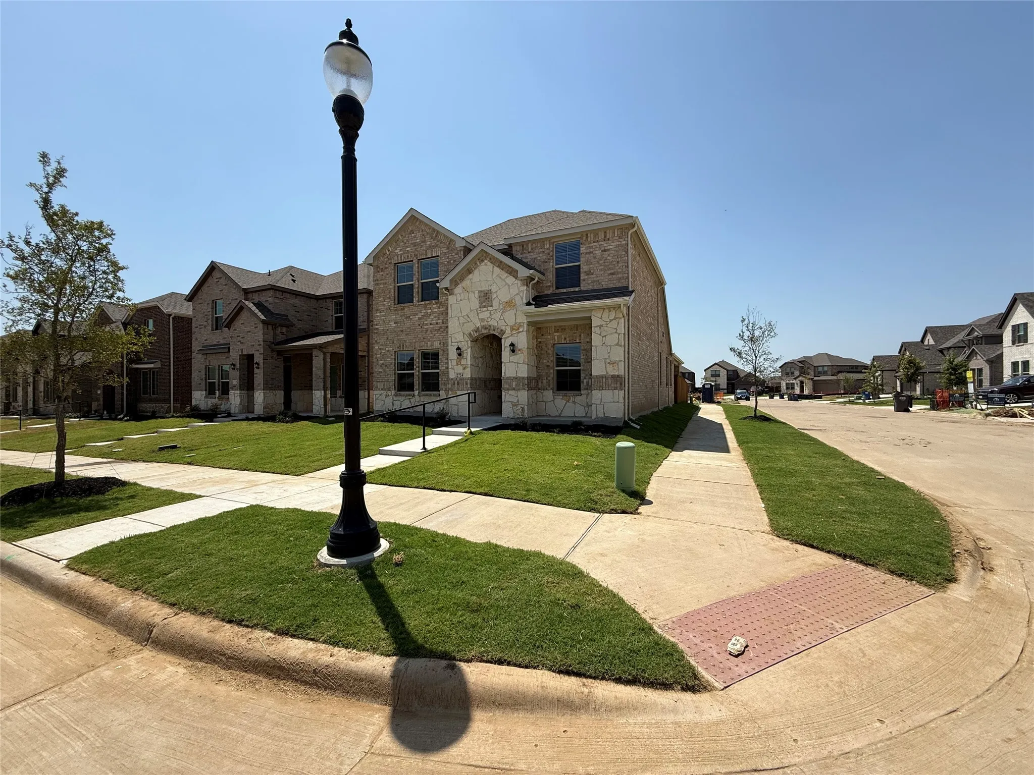 Two-story residence featuring a brick and stone facade, arched entryway, and dark-framed windows