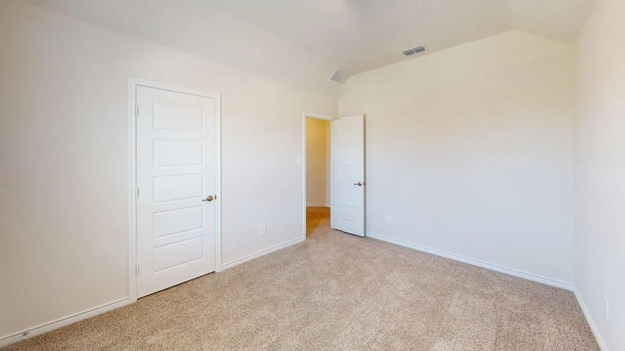 Carpeted interior room featuring neutral wall paint, white five-panel interior doors, and white baseboards
