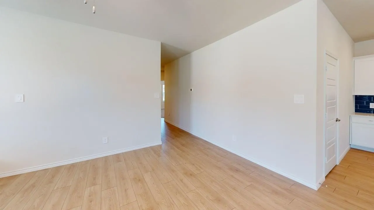 Open-concept interior featuring wood-finish flooring, white walls, and white baseboards