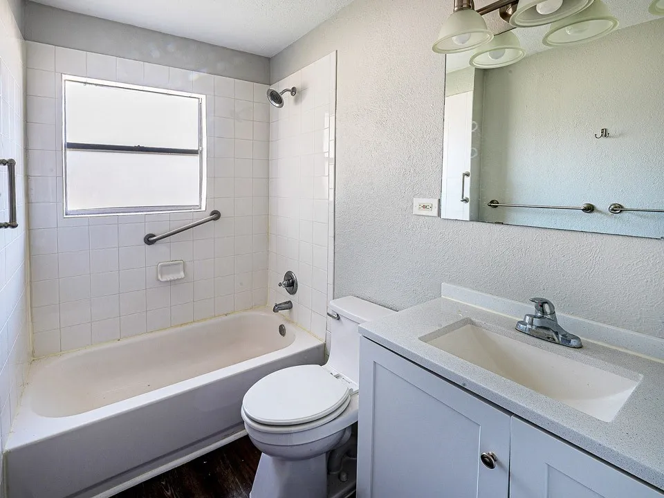 Bathroom featuring a white vanity with a light-colored countertop, an integrated sink, and an overhead vanity light fixture