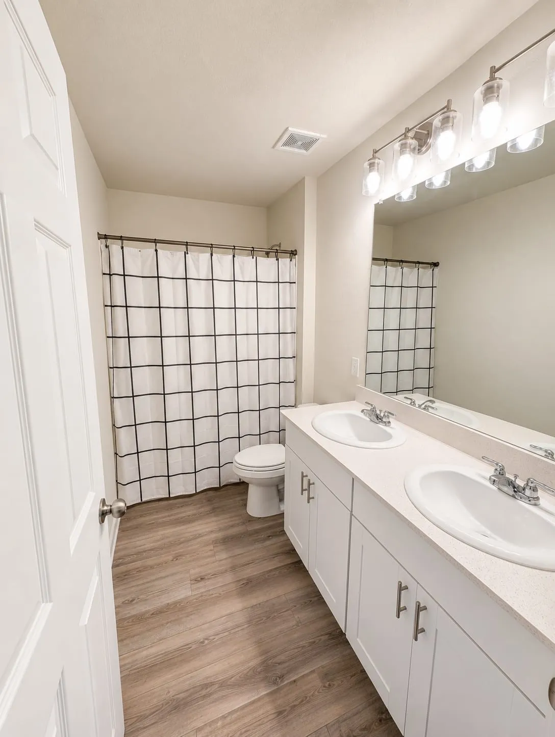 Bathroom featuring a dual vanity with white cabinetry, light-toned countertops, and two undermount sinks