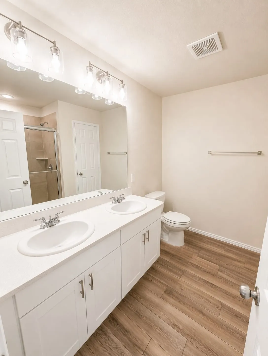 Dual vanity featuring white cabinetry, integrated sinks, and a large mirror