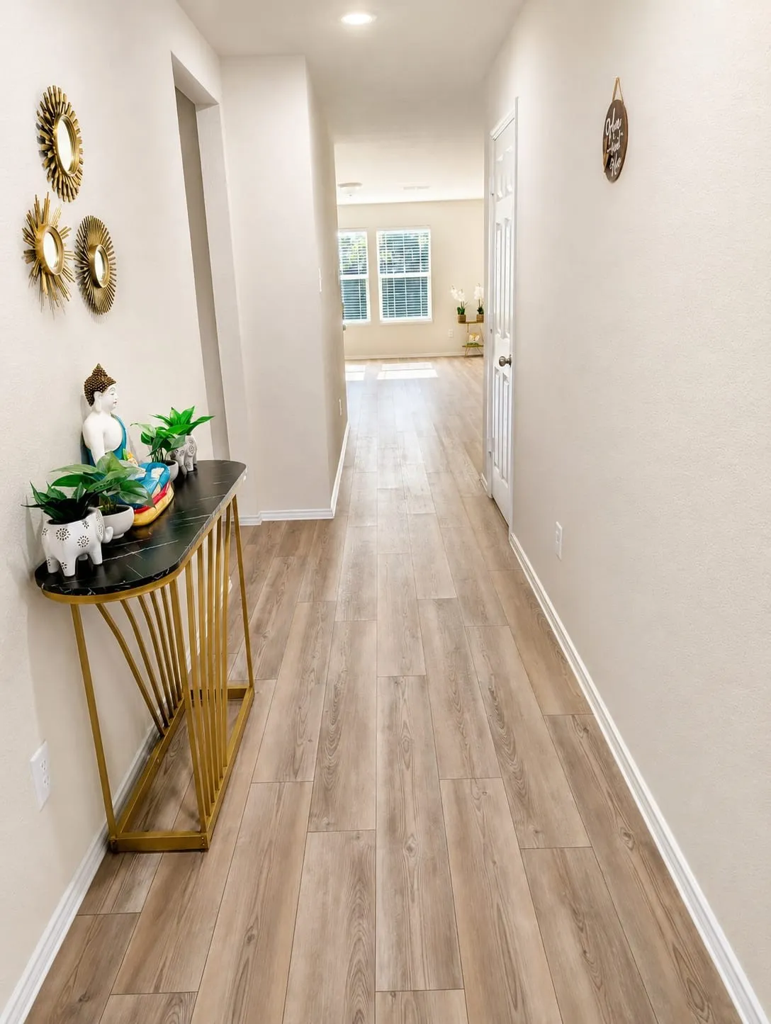 Light wood-finish flooring extending through a long hallway