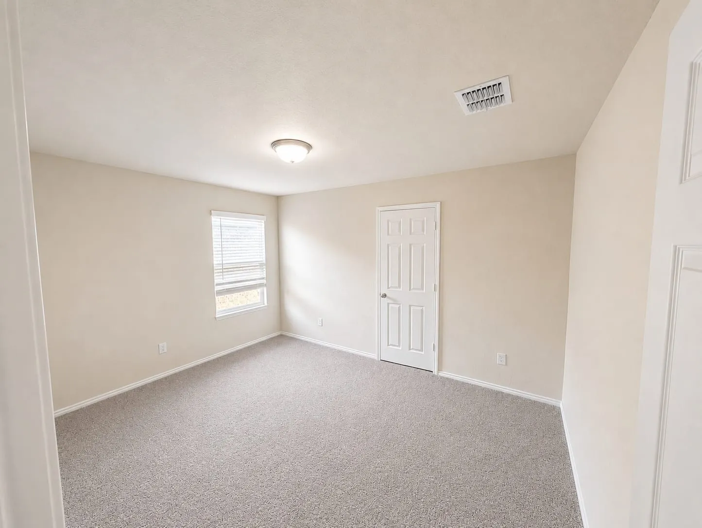 Neutral-toned walls complement the gray carpeting