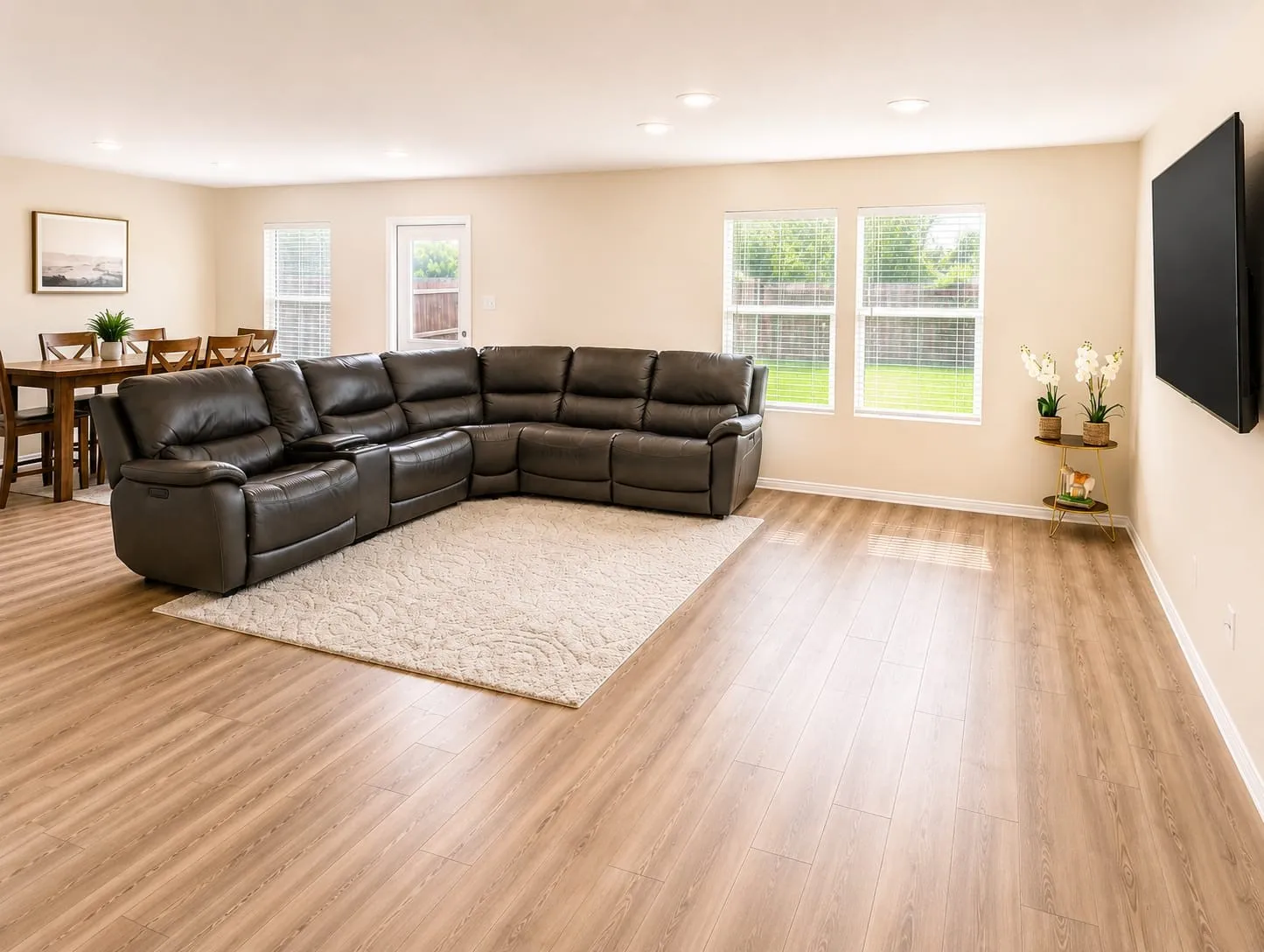 Open-concept living space featuring wood-finish flooring, recessed lighting, and ample natural light from multiple windows