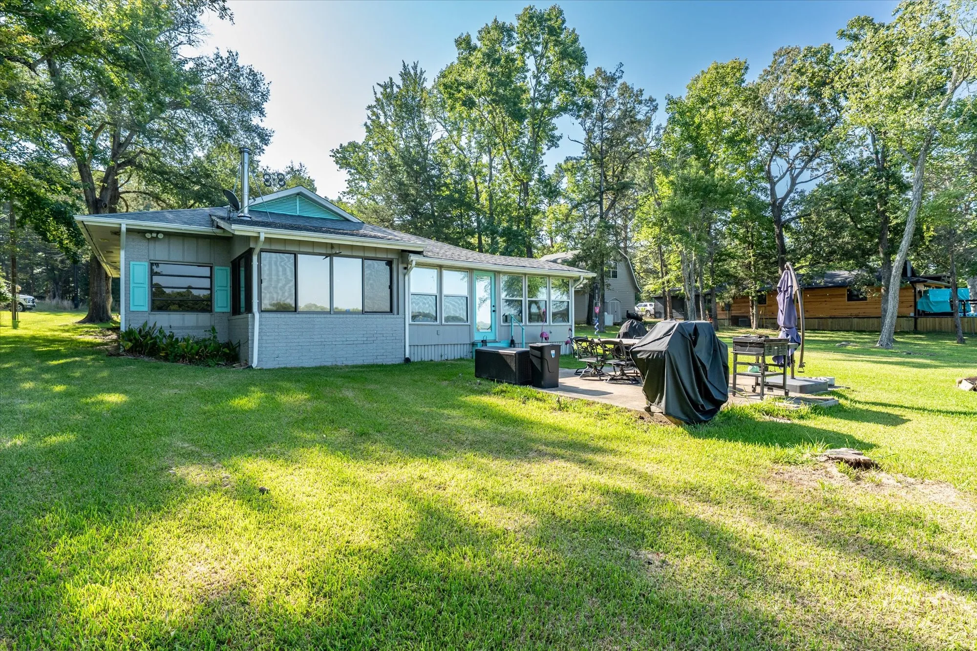 Expansive grassy yard with mature trees surrounding the property