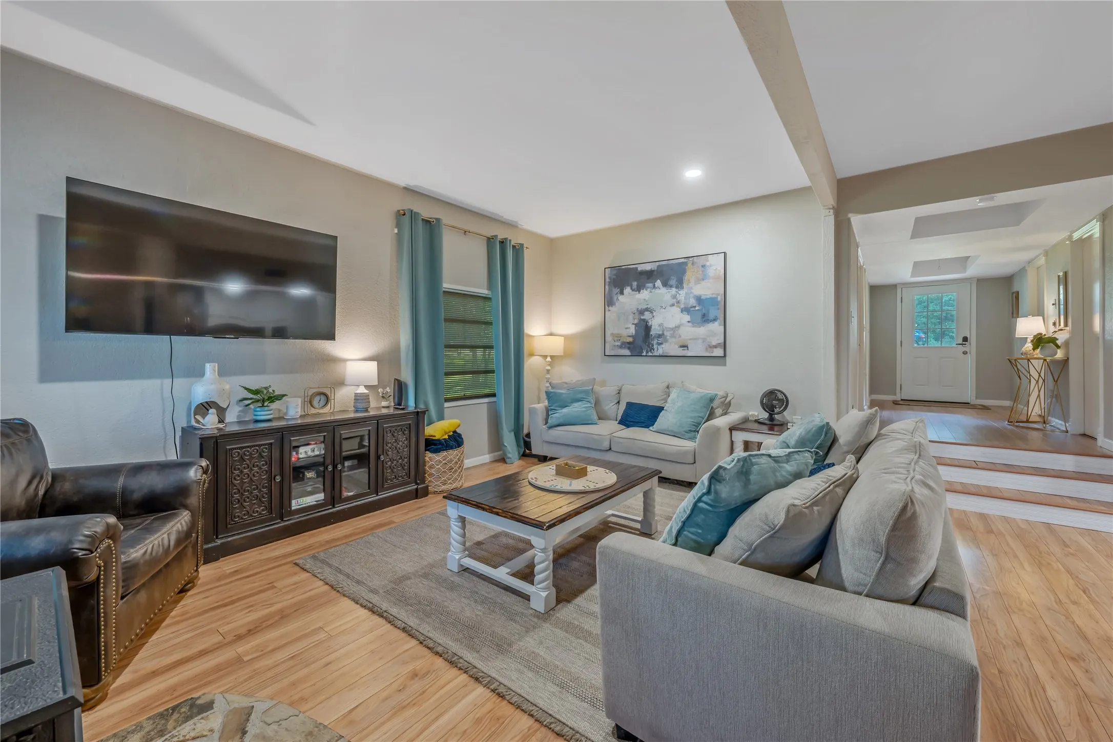 Open living area featuring wood-finish flooring, recessed lighting, and a neutral wall palette