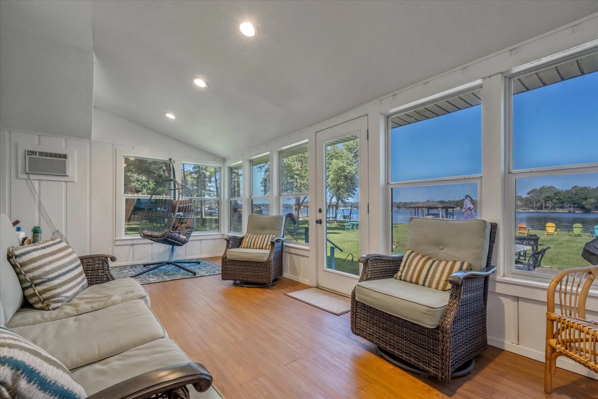 Sunroom with wood-finish flooring and a vaulted ceiling