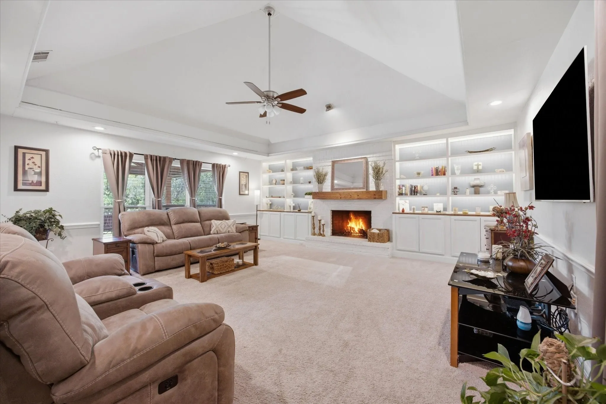 Living room featuring a tray ceiling, ceiling fan, and recessed lighting