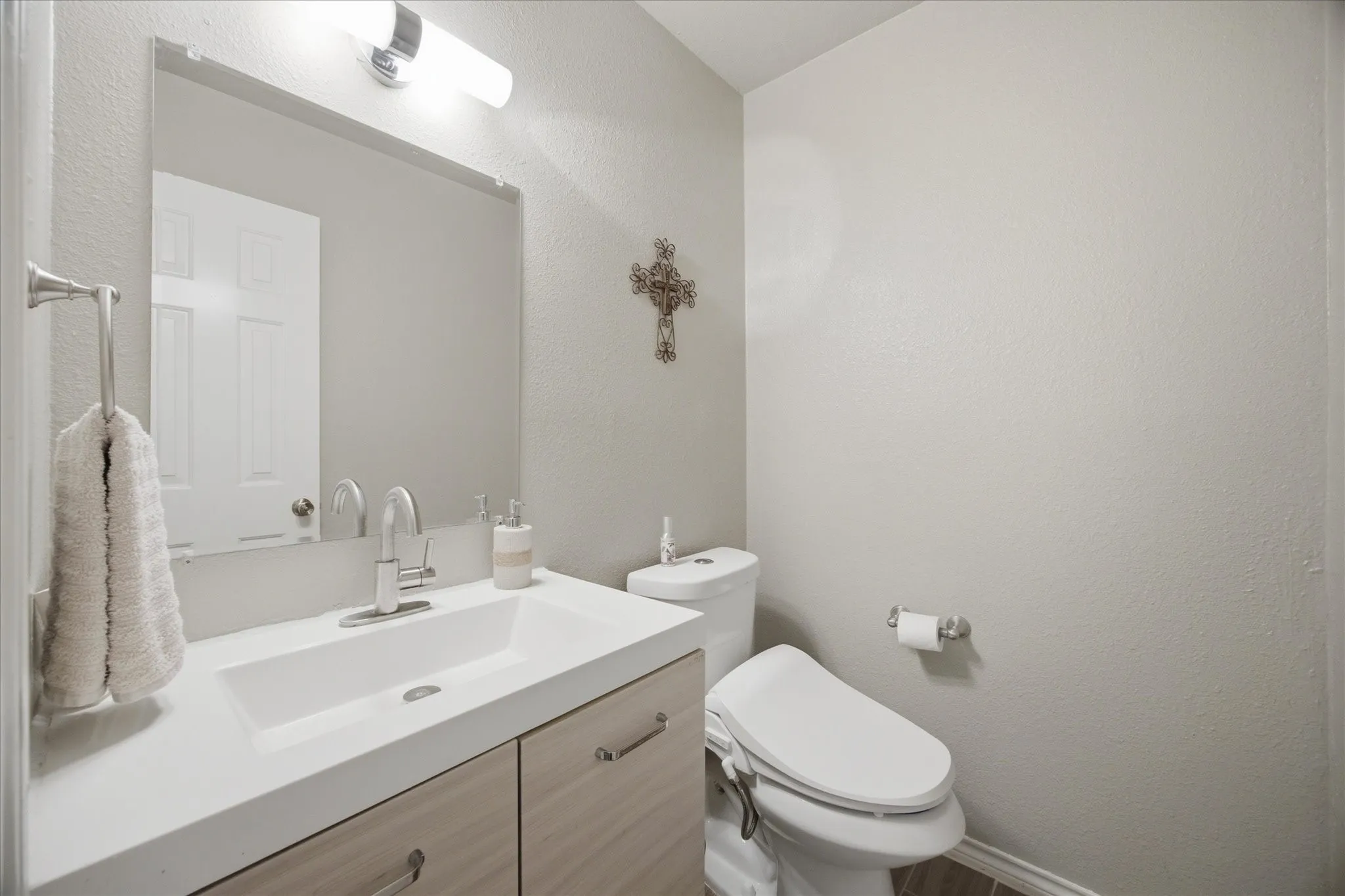Bathroom featuring a vanity with an integrated sink, brushed nickel faucet, and wood-finish cabinetry